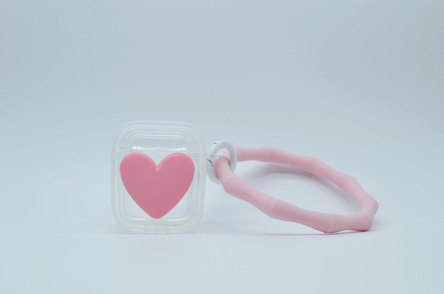 Protector para Airpods transparente con corazón rosa y pulsera de silicón