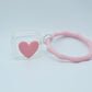 Protector para Airpods transparente con corazón rosa y pulsera de silicón