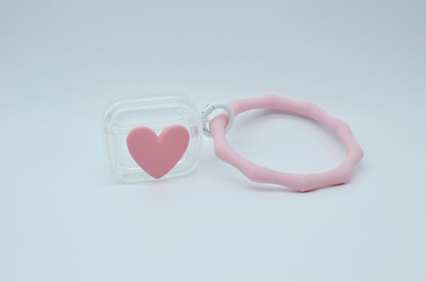 Protector para Airpods transparente con corazón rosa y pulsera de silicón