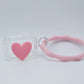 Protector para Airpods transparente con corazón rosa y pulsera de silicón